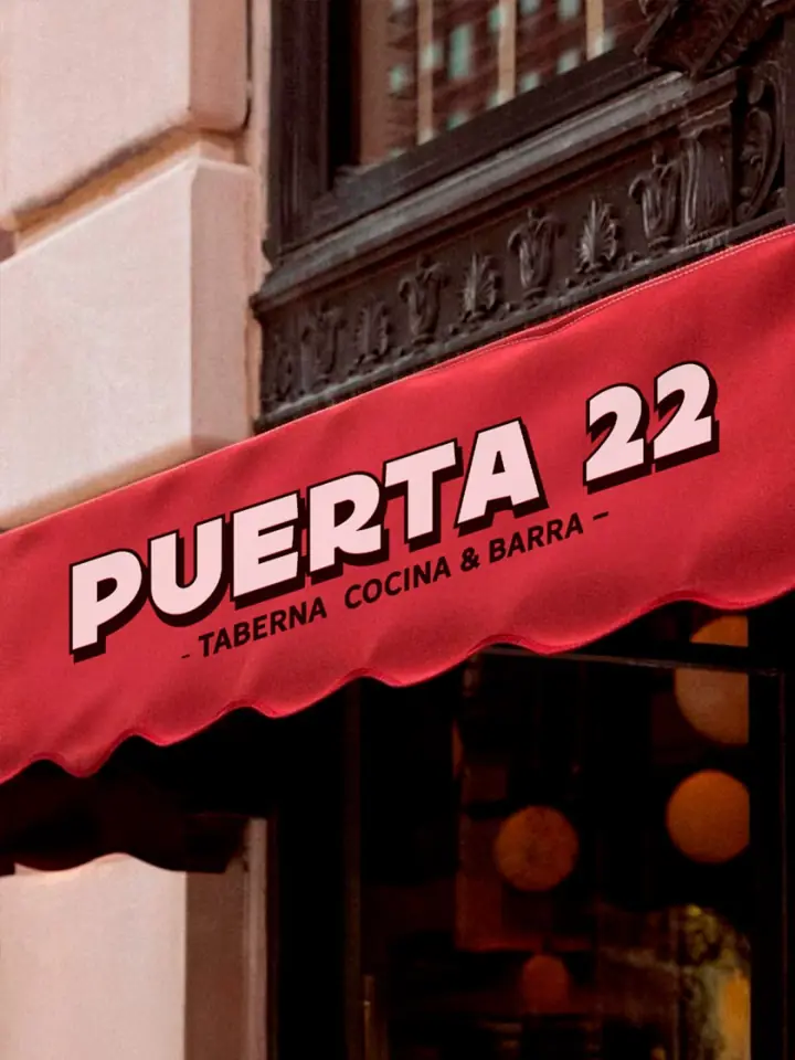 El toldo rojo de Puerta 22 sobre la puerta de entrada